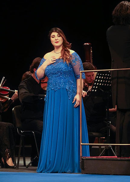 Nella foto è presente il soprano Marta Mari con la mano sul petto e gli occhi abbassati durante un passaggio dell’aria del concerto.
